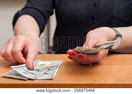 Womans Hands Counting Hundred Dollar Bills Over The Table. Selective Focus