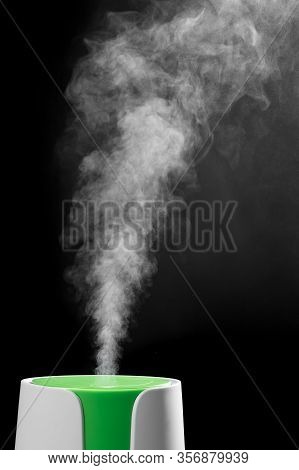 Ultrasonic Humidifier Releases Water Vapor From The Hole. On Black Background. The Process Of Operat