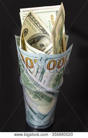 Hundred Dollar Bills Are Twisted Into A Tube And Placed In A Glass. Decoration Of Money. Selective F