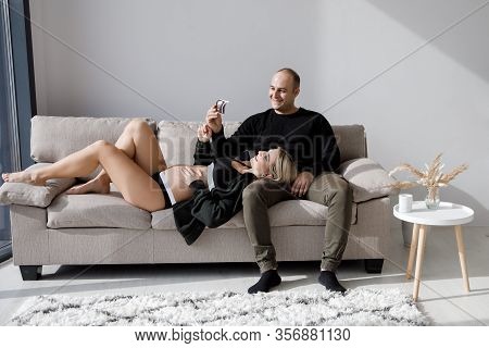 Couple Of Handsome Husband And Pretty Pragnant Woman Posing At Studio Embracing Stomach. Young Styli