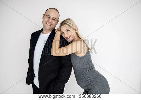 Young Pretty Blonde, Expectant Mother, Stands Next To Her Husband. Young Couple, Man And Woman, Beau