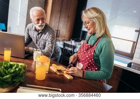 Happy Retired Couple Browsing The Internet Together On A Laptop Computer.quarantine. Health Concept.