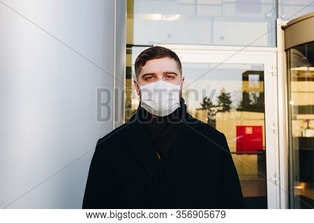Caucasian Young Man Near His Office Wearing Surgical Face Mask To Protect From Coronavirus Covid-19