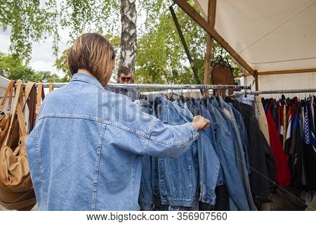 Berlin, Germany - 7 July 2019: A Girl At The Fleamarket At Mauerpark Looking Jeans Jackets