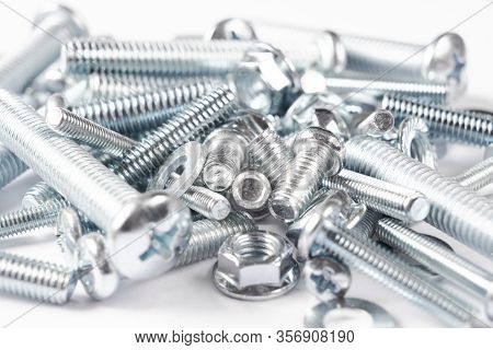 Metal Bolts And Nuts  In A Row Background. Chromed Screw Bolts And Nuts Isolated. Steel Bolts And Nu
