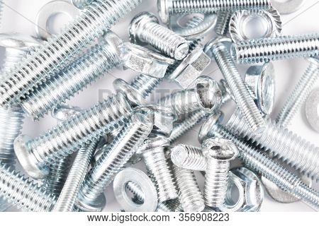 Metal Bolts And Nuts  In A Row Background. Chromed Screw Bolts And Nuts Isolated. Steel Bolts And Nu