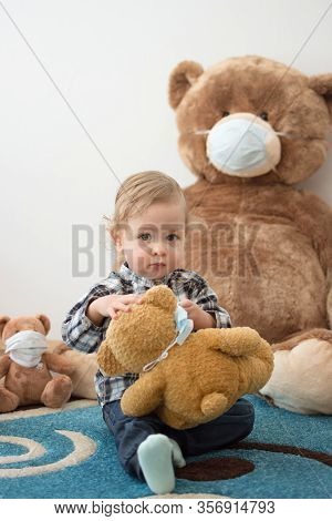 Child Playing With His Sick Teddy Bears Wearing Medical Mask Against Viruses. Role Playing, Child Pl