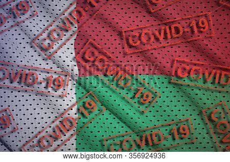 Madagascar Flag And Many Red Covid-19 Stamps. Coronavirus Or 2019-ncov Virus Concept