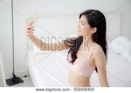 Beautiful Young Asian Woman Sexy In Underwear Talking A Selfie On Smartphone For Social Network In T
