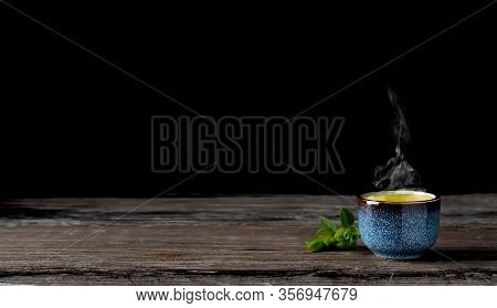 Bowl With Matcha Green Tea On A Vintage Wooden Table, Steam From Hot Tea Rises Above The Cup, Dark B