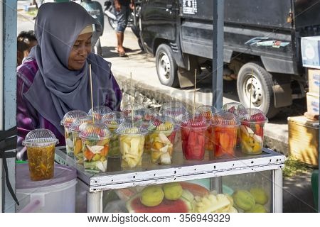 Banda Aceh, Indonesia - January 5, 2020. Saleswoman In The Muslim Dress Sells On The Street Counter 