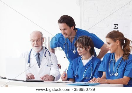 Medical Doctors Team Using Laptop At Consultation In Clinical Office