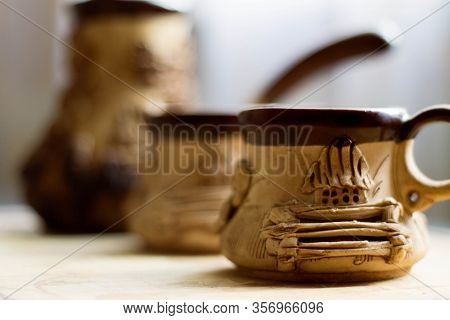 Handmade Clay Mugs And Cezve (coffee Pot) With Blurred Background