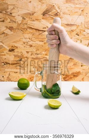 Girl Squeezes Juice From Lime To Make Mojito. Mixing Peppermint And Lime. A Refreshing Summer Alcoho