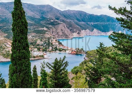 Frourio Peninsular And Assos Village With Beautiful Sea Bay And Cypress Trees In Foreground. Kefalon
