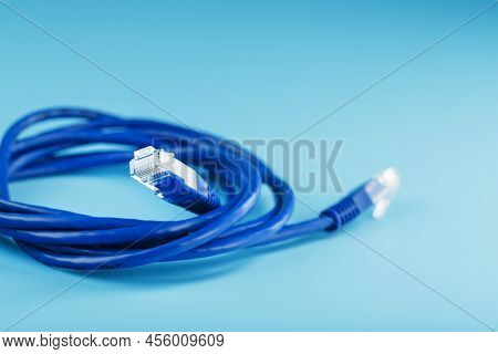 A Coil Of An Internet Network Cable For Data Transmission On A Blue Background