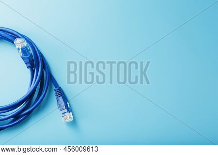 A Coil Of An Internet Network Cable For Data Transmission On A Blue Background