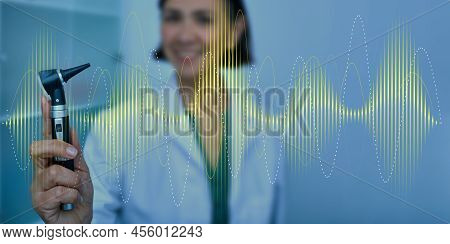 Audiologist With Otoscope On Sound Waves Background. Hearing Treatment Concept