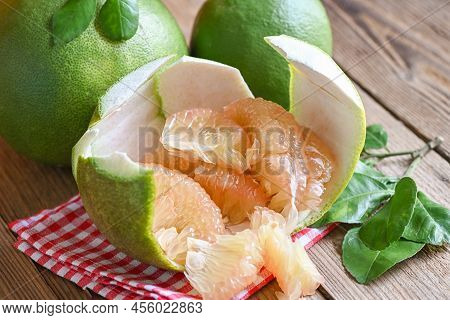 Pomelo Fruit On Wooden Background, Fresh Green Pomelo Peeled On Pomelo Skin And Leaf Frome Pomelo Tr