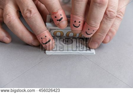 Man's Fingers Are Counting Money. Wad Of American Hundred-dollar Bills. The Index And Middle Fingers