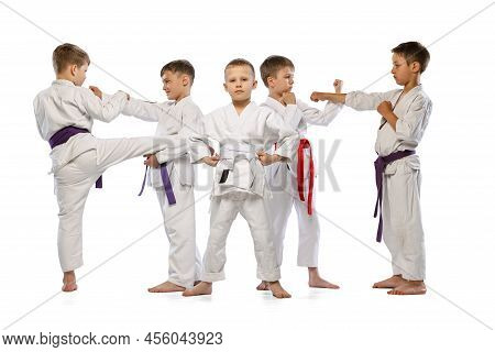 Group Of Happy Children, Beginner Karate Fighters In White Doboks Standing Together Isolated On Whit