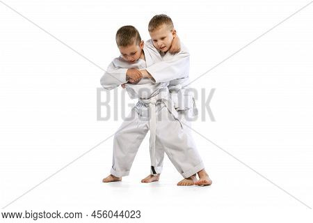 Dynamic Portrait Of Two Little Boys, Taekwondo Or Karate Athletes Wearing Doboks Training Together I