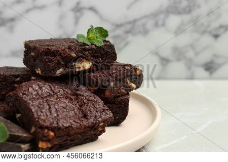 Delicious Chocolate Brownies With Nuts And Fresh Mint On Light Grey Table, Closeup. Space For Text