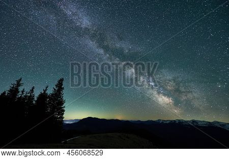Magical Starry Night Over Mountain Beskids. Silhouettes Of Trees, Hills And Snow-capped Mountain Pea