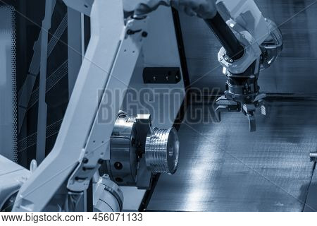 The Automatic  Robotic Arm Gripping The Metal Parts From Cnc Lathe Machine. The Hi-technology  Mater