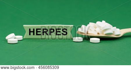 Medicine Concept. On A Green Surface, A Wooden Spoon With Pills And A Sign With The Inscription - He