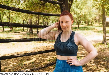 Young Athlete, In Sportswear Looking At Camera Standing In Front Of A Trellis Outdoors. Athlete Prac