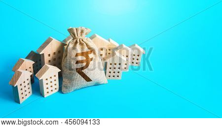 Indian Rupee Money Bag Surrounded By Houses. Real Estate Investment. Mortgage Loan. Budget And Fundi