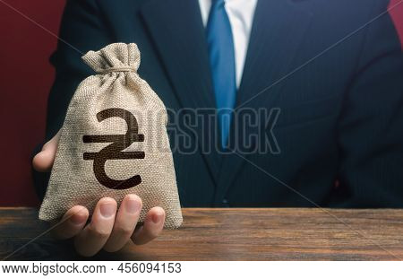 A Businessman Holds Out A Money Bag With Ukrainian Hryvnias. Fundraising And Funding Post-war Recons