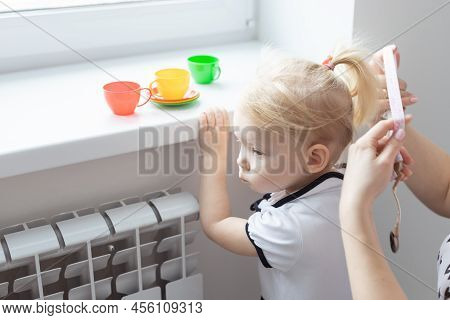 Mother Fixing Her Daughters Cochlear Implant Hearing Aid - Deafness And Diversity Concept. Innovativ