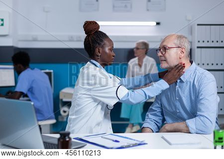 Clinic Specialised Otologist Examining Senior Man While Touching His Neck. Clinic Worker Consulting 