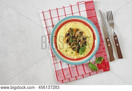 A Portion Of Polenta Or Corn Grits With Fried Mushrooms In A Colored Plate On A Light Background. Po