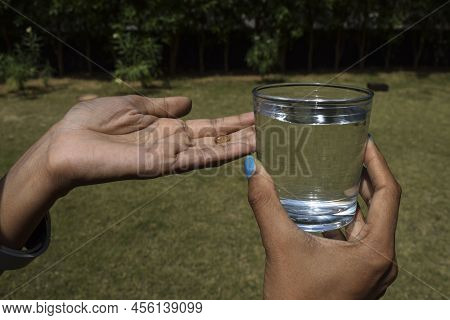 Vitamin D Capsule Yellow Color Soft Shelled Gel Pills Tablet In Hand. Patient Taking Vitamin Supplem