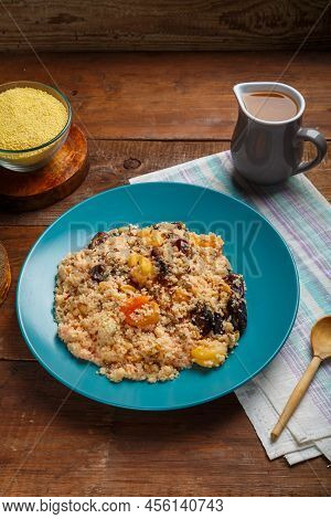 A Plate Of Couscous With Dried Fruits And Nuts On A Wooden Table Next To The Ingredients. Vertical P