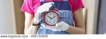 Close-up Of Woman Worker In Uniform Holding Red Clock Reminder To Finish Work On Time. Foreman At Co