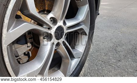 The Original Alloy Wheel, Dirty And Scratched On The Car Close-up. Worn Car Wheels Are Waiting For R