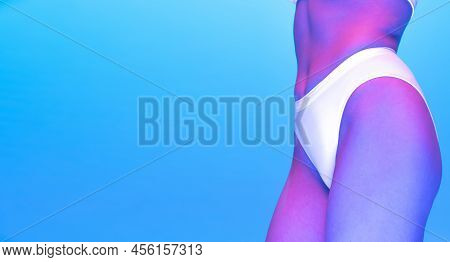 Cropped Mage Of Slim Female Body, Bottocks In White Underwear Isolated Over Blue Background In Neon 
