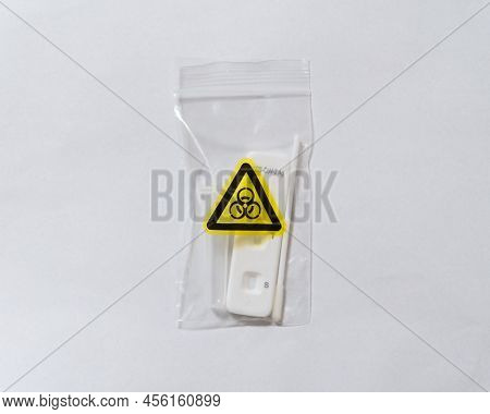 Covid Antigen Test Kit Placed In A Biohazard Waste Bag After Testing On A White Background. Biohazar