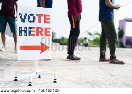 People In Line Waiting For Casting Vote Near Polling Booth Vote Here Sign Board - Concept Of Rights,