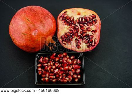 Sliced Red Pomegranate On A Black Slate