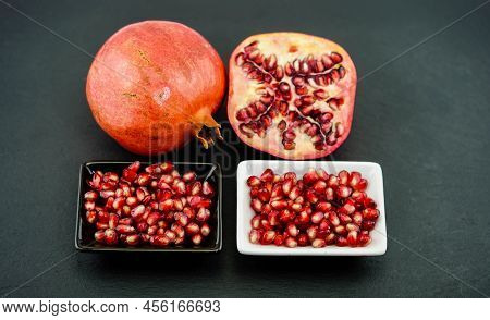 Sliced Red Pomegranate On A Black Slate