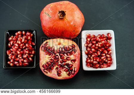 Sliced Red Pomegranate On A Black Slate