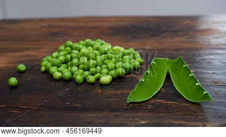 Fresh Peeled Green Pease On A Brown Wooden Table With Copy Space. Fresh Pods Of Green Peas Horizonta