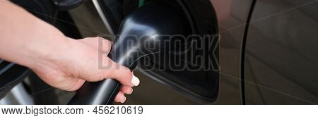 Close-up Of Woman Put Fuel Nozzle On Petrol Station To Refuel Automobile With Diesel. Black Car On P