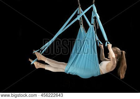 Side View Portrait In Full Growth Girl Trains Aerial Gymnastics In Sports Hammock. Fly Yoga. Anti-gr
