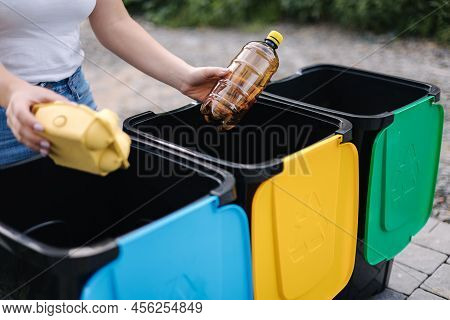 Middle Selection Of Female Hold Two Different Type Of Rubbish, Plastic Bottle And Egg Carton And Tho